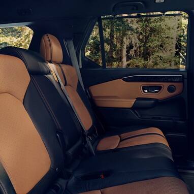 2027 Honda Passport TrailSport Elite featuring brown and black leather rear seats and door panel (Mid-Size SUV).